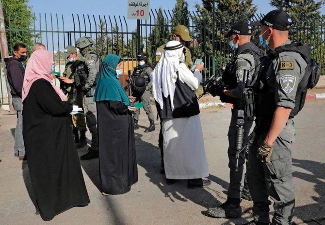 Palestinians entering Jerusalem to attend Ramadan’s first Friday prayers at Al-Aqsa Mosque, show their covid-19 vaccination certificates at Israeli checkpoints. (AFP)