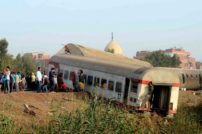 People gather at the site where a passenger train derailed injuring at least 100 people, near Banha, Qalyubia province, Egypt, Sunday, April 18, 2021. (AP)