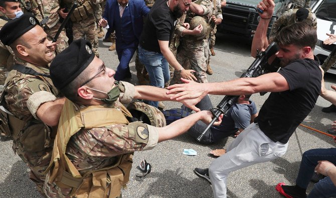 An opponent of Judge Ghada Aoun grabs the weapon of a soldier, after he hit the protester with it, during a sit-in outside the Justice Palace in Beirut, Lebanon, Monday, April 19, 2021. (AP)