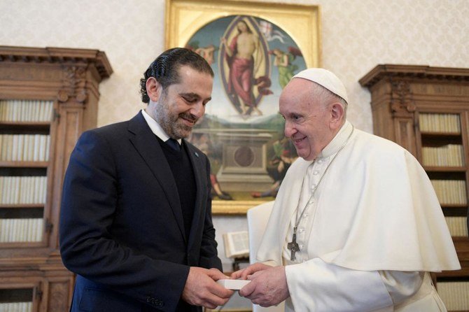 Pope Francis and Lebanon's prime minister-designate Saad Hariri exchange gifts during a private audience in The Vatican. (AFP)
