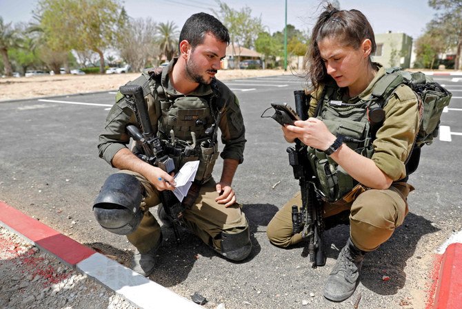 Israeli soldiers inspect a piece of debris from a missile launched from Syria that landed in the vicinity of Israel's Dimona nuclear site on April 22, 2021. (AFP / Ahmad Gharabali)