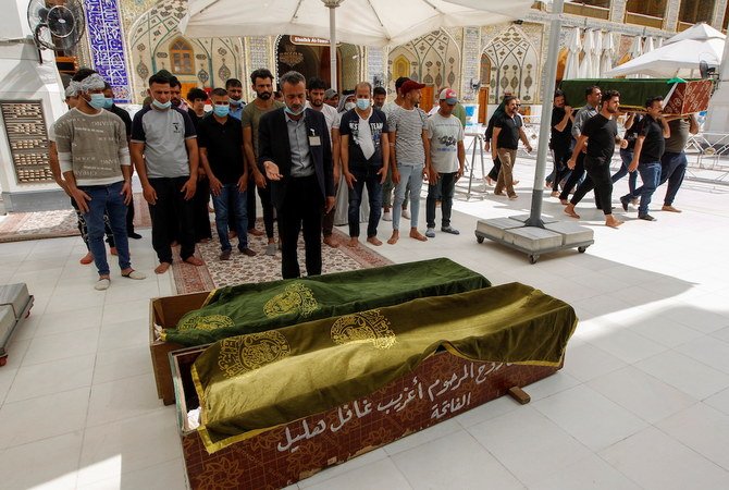 Mourners pray next to the coffins of people who were killed in a fire at a hospital in southeastern Baghdad that had been equipped to house COVID-19 patients, in Najaf, Iraq, April 25, 2021. (Reuters)