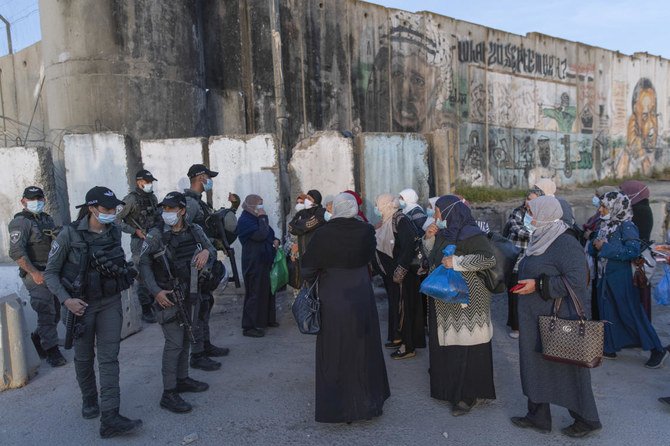 Palestinian women wait to cross the Qalandia checkpoint between Ramallah and Jerusalem, to attend the first Friday prayers in al-Aqsa mosque, Friday, April 16, 2021. (AP)