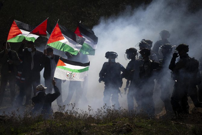 In this Dec. 3, 2020. file photo, Israeli border police officers and Palestinians clash during a protest against the expansion of Israeli Jewish settlements near the West Bank town of Salfit. (AP)i