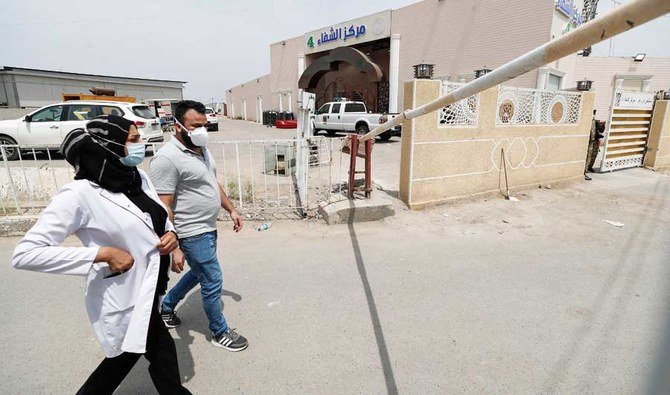 Medical staff walk past the closed-off entrance of Ibn Al-Khatib Hospital in Baghdad, on April 25, 2021. (AFP)