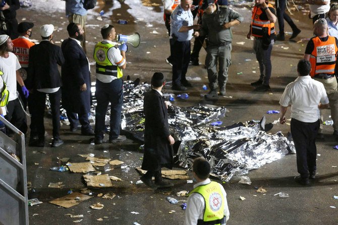 Videos posted on social media showed chaotic scenes as Ultra-Orthodox men clambered through gaps in sheets of torn corrugated iron to escape the crush. (AFP)