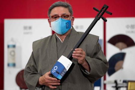 Japanese craftsman Kimiaki Kono, who created a special Tokyo 2020 branded shamisen, attends a Tokyo 2020 press event of a traditional crafts collection in Tokyo on April 15, 2021. (AFP)