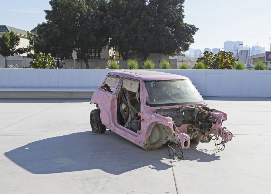 Sarah Abu Abdallah, Saudi Automobile, 2011. Colour video with sound, car and pink paint; 10-minute single channel HD video on loop. Installation view: Unsettled Objects, Sharjah Art Foundation, 2021. Reproduced by Sharjah Art Foundation. (Photo: Sharjah Art Foundation) 