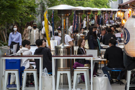 People sit in the outdoor seating areas of restaurants and bars on Tuesday, April 20, 2021, in Tokyo. (AP)