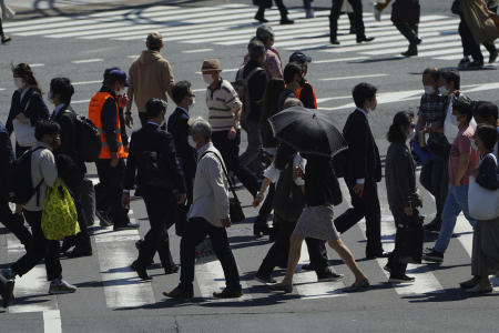People wearing protective masks to help curb the spread of the coronavirus walk along a pedestrian crossing Wednesday, April 21, 2021, in Tokyo. (AP)
