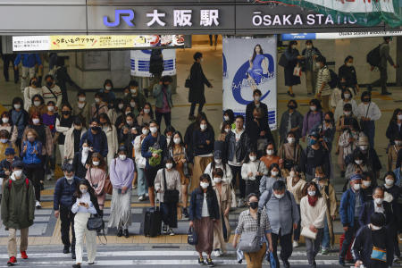 People wear face masks as they make their way in Osaka, western Japan, on Wednesday. (Kyodo News via AP)