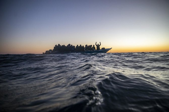 Migrants and refugees wait for assistance aboard an overcrowded wooden boat in the Mediterranean Sea, off the coast of Libya, Feb. 12, 2021. (AP Photo)