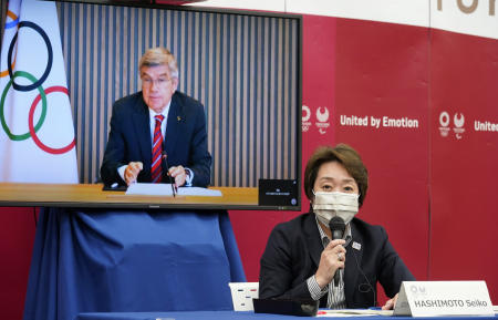 International Olympic Committee (IOC) president Thomas Bach (on a screen) listens to the opening speech of Tokyo 2020 Organizing Committee president Seiko Hashimoto during a five-party meeting of Tokyo 2020 Olympic and Paralympic Games in Tokyo, Wednesday, April 28, 2021. (AP)