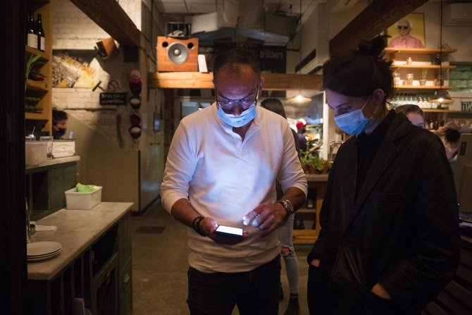 A customer prepares to present a COVID-19 vaccination certificate on entering a restaurant in Tel Aviv, Israel. (Getty Images)