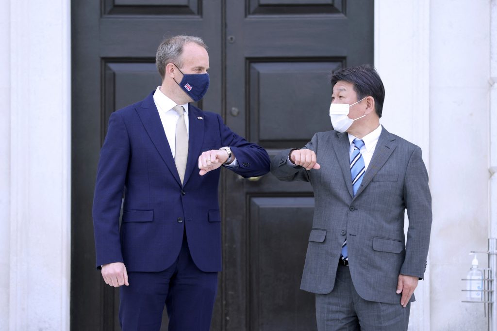 Britain's Foreign Secretary Dominic Raab (L) and Japan's Foreign Minister Toshimitsu Motegi touch elbows as they gree ahead of a bilateral meeting at Chevening House in Chevening, south east of London, on May 3, 2021. (AFP)