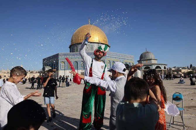 Muslim children celebrate after the morning Eid al-Fitr prayer at the Al-Aqsa mosques compound in Old Jerusalem Friday early morning. (AFP)