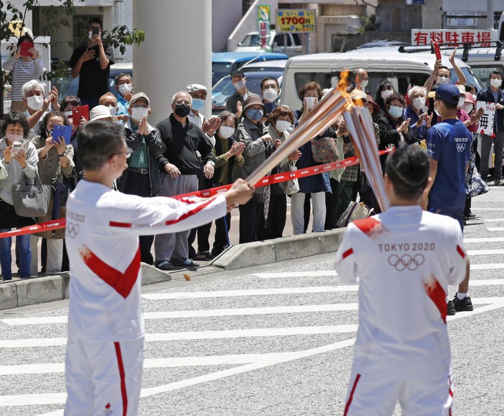 The Olympic flame is passed from torch to torch during the Tokyo 2020 Olympics torch relay on Amami-Oshima Island in Kagoshima Prefecture, southwestern Japan, April. 27, 2021. (File photo/Kyodo via Reuters)