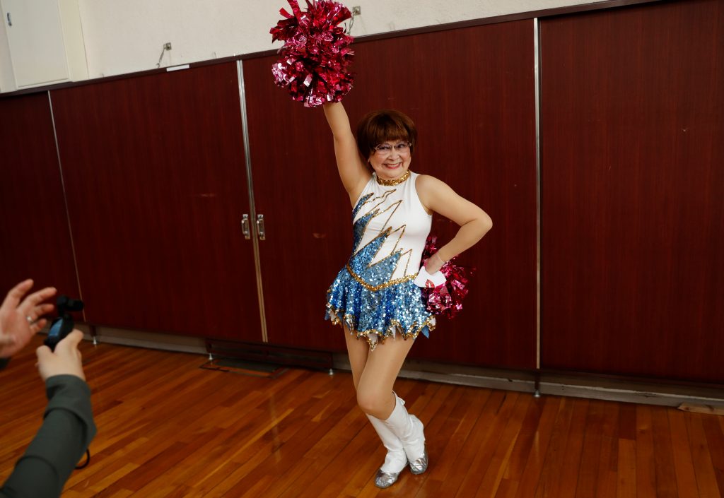 Fumie Takino, 89, founder of a senior cheer squad called Japan Pom Pom, poses for a commemorative photo before filming a dance routine for an online performance in Tokyo, Japan, April 12, 2021. (Reuters)