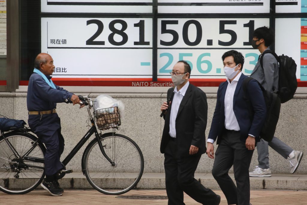 People walk by an electronic stock board of a securities firm in Tokyo, Wednesday, May 19, 2021. Asian shares fell Wednesday, tracking a decline on Wall Street led by big technology stocks. (AP Photo/Koji Sasahara)