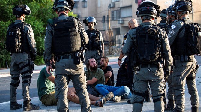 Israeli paramilitary border police detain Jewish settlers after clashes between Arabs and Jews in the mixed town of Lod, May 12, 2021. (AP Photo)