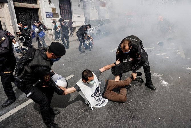 Riot police officers detain demonstrators as they attempt to defy a ban and march on Taksim Square to celebrate May Day, during a nationwide 