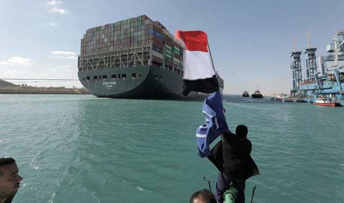A man waves an Egyptian flag after Ever Given, one of the world's largest container ships, was fully floated in Suez Canal, Egypt March 29, 2021. (Reuters)