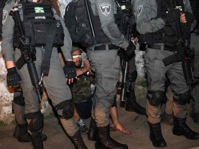 A blindfolded Palestinian demonstrator is surrounded by Israeli security forces, as Palestinian families face eviction as Jewish Israelis take control of homes in the Sheikh Jarrah neighborhood of occupied east Jerusalem. (AFP)