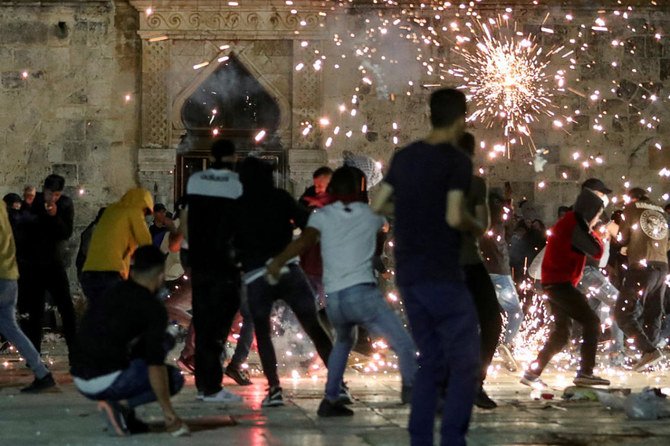 Palestinians react as Israeli police fire stun grenades during clashes on May 7, 2021, at the compound that houses Al-Aqsa Mosque in Jerusalem's Old City amid tension over the possible eviction of several Palestinian families from their homes. (Reuters)