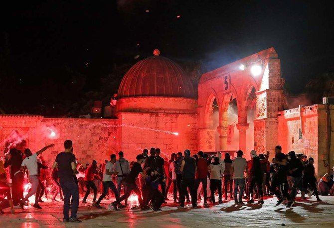 Palestinian protesters hurl rocks and flares amid clashes with Israeli security forces at the al-Aqsa mosque compound in Jerusalem, on May 7, 2021. (AFP)