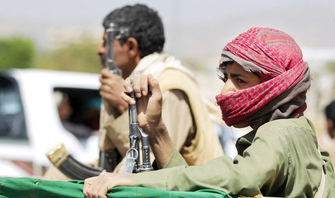 An armed supporter of the Houthis sits in the back of a pick-up. (AFP/File)