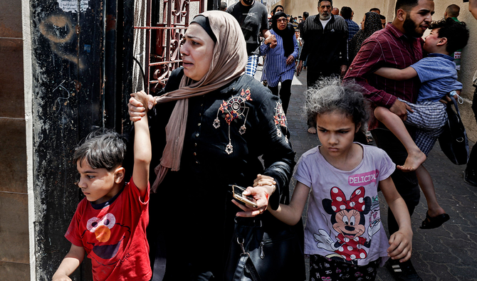 A Palestinian woman cries as civilians evacuate a building targeted by Israeli bombardment in Gaza City on May 11, 2021. (AFP)