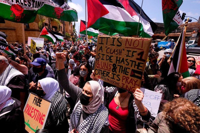People wave signs and Palestinian flags during a protest against Israel and in support of Palestinians outside Israeli Consulate in Los Angeles. U.S. dispatched a senior diplomat on Wednesday to urge Israelis and Palestinians to quench violence. (AFP)