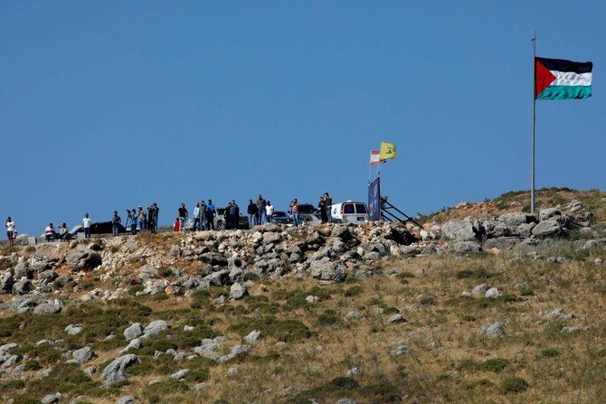 People and reporters watching after a pro-Palestinian rally in the Lebanese Khiam area, on Friday. A Lebanese demonstrator died and another was wounded by Israeli fire when dozens rallied to protest strikes on Gaza Strip. (AFP)