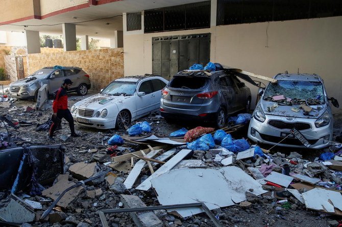 A Palestinian man walks past damaged vehicles in the aftermath of Israeli air strikes, amid a flare-up of Israeli-Palestinian violence, in Gaza City on May 15, 2021. (Reuters)