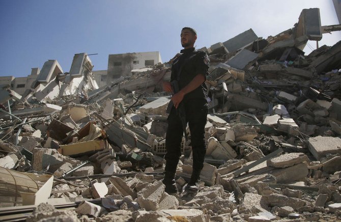A man stands on rubble from a building housing AP office and other media in Gaza City that was destroyed after Israeli warplanes demolished it, Saturday, May 15, 2021. (AP)