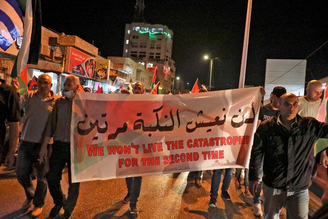 Palestinians march with a banner reading 