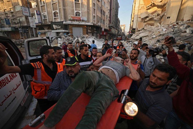 Palestinians carry one of survivors from under the rubble of a building after it was hit by Israeli strikes in Gaza City on May 16, 2021. (AFP)