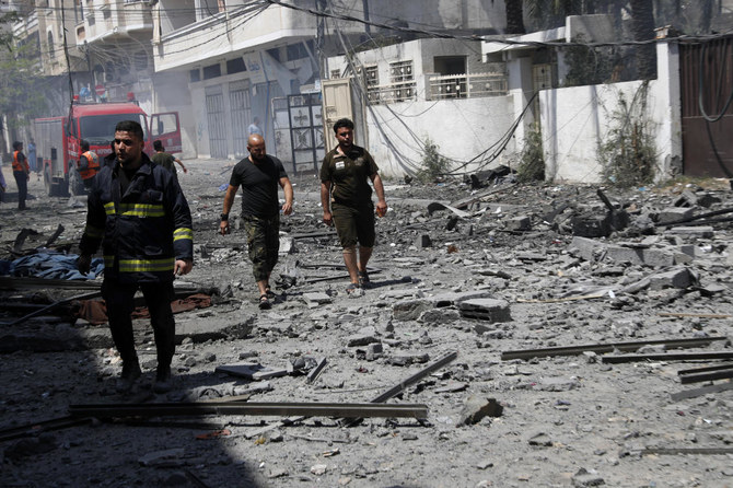 A firefighter and others inspect the rubble of a residential building that was hit by an Israeli airstrike, in Gaza City, Sunday, May 16, 2021. (AP)