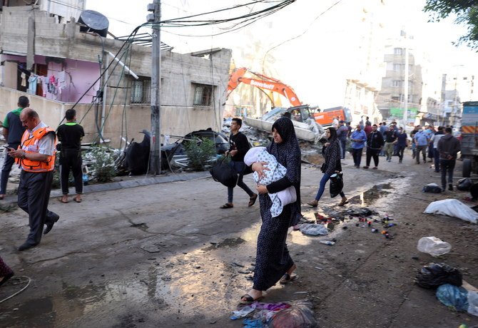 People walk past debris in a street at the site of Israeli air strikes, in Gaza City May 16, 2021. (Reuters)