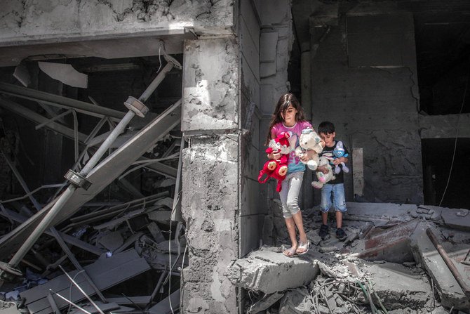 Palestinian children salvage toys from their home at the Al-Jawhara Tower in Gaza City, on May 17, 2021, which was heavily damaged in Israeli airstrikes. (Anas Baba/AFP)