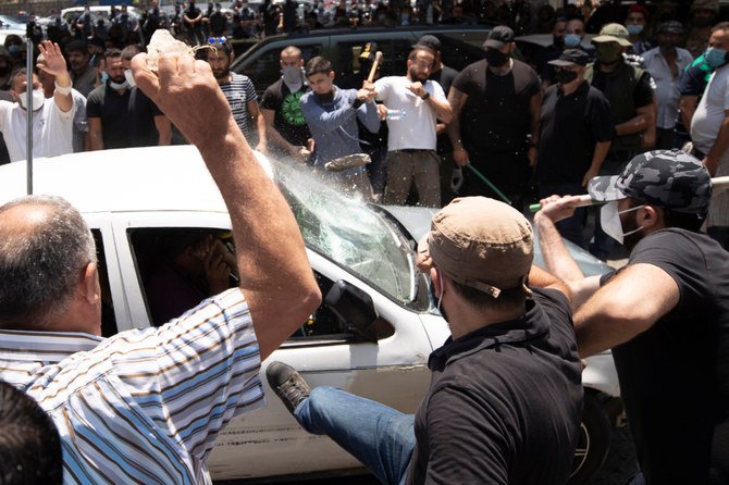 Members of the Christian rightwing Lebanese Forces group attack a car carrying Syrian voters before heading to the Syrian embassy to vote, in the town of Zouk Mosbeh, north of Beirut, Lebanon, Thursday, May 20, 2021. (AP)