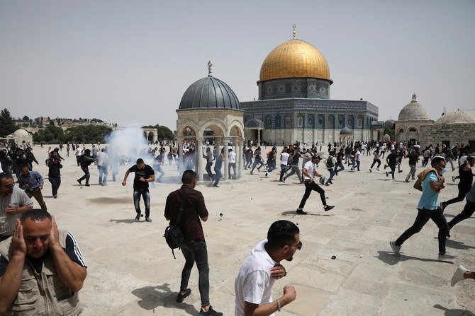 Palestinians run from sound grenades thrown by Israeli police in front of the Dome of the Rock in the Al-Aqsa mosque complex in Jerusalem, as a cease-fire took effect between Hamas and Israel after 11-day war. (AP)