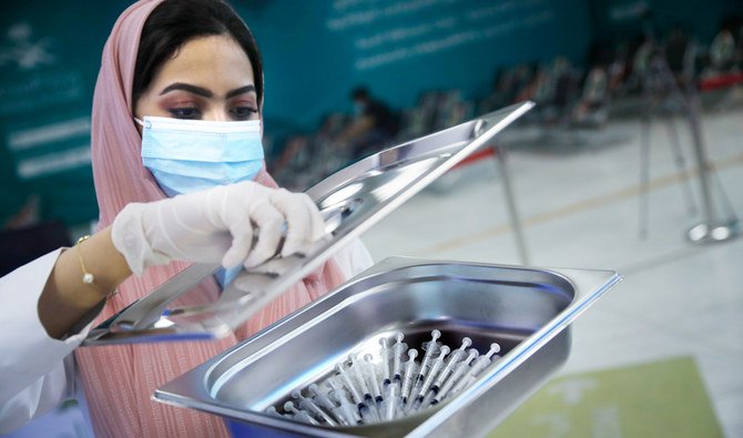 A Saudi health worker carries a tray of Pfizer coronavirus vaccines, at a vaccination center in the old Jeddah airport, Saudi Arabia, May 18, 2021. (AP)