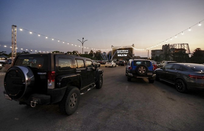 People sit in their cars as they watch a movie in a drive-in cinema at a park, in Byblos on July 18, 2020. (File/AFP)
