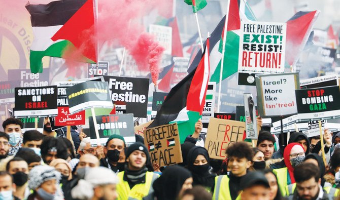 Protesters in London hold placards as they take part in Saturday’s rally supporting Palestinians. Similar demos were also held in France and Pakistan. (AP)