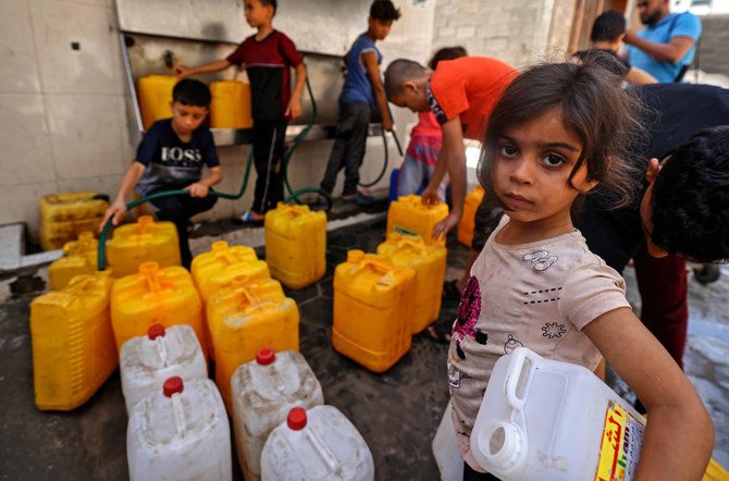 Children fill up gallons with water in Gaza City on May 20, 2021 amid the death and destruction from Israeli bombardment.(AFP / MAHMUD HAMS)