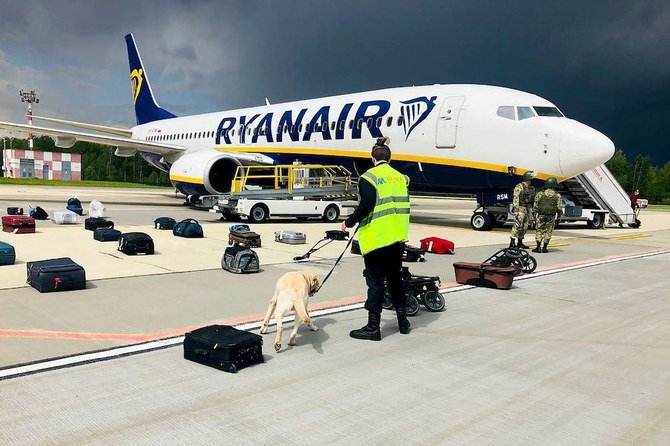 A Belarusian dog handler checks luggages off a Ryanair Boeing 737-8AS (flight number FR4978) parked on Minsk International Airport’s apron in Minsk, on May 23, 2021. (AFP/Onliner.by)