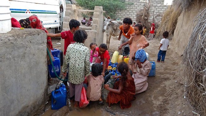 Yemenis fill their jerrycans with water at a make-shift camp for the internally displaced in Hodeida on May 7, 2021. (File/AFP)