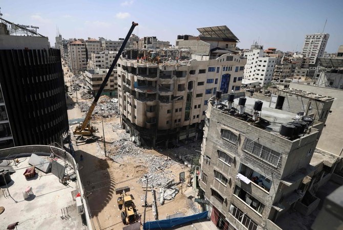 Palestinian workers demolish a building that was damaged during last week's Israeli airstrikes, in the Al-Rimal neighbourhood in Gaza city, on May 29, 2021. (AFP)