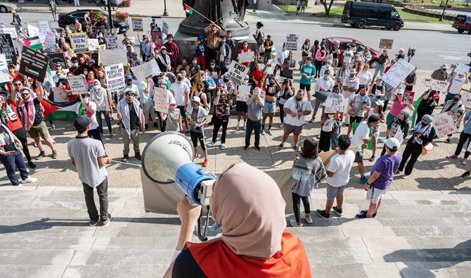 People chant and hold signs while listening to a speaker during a pro-Palestine protest on the steps of City Hall on May 23, 2021 in Louisville, Kentucky. (AFP)